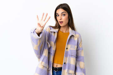 Young caucasian woman isolated on purple background happy and counting four with fingers
