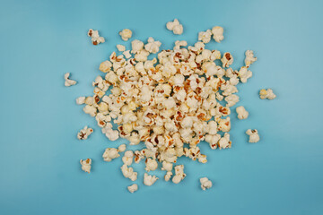 a pile of popcorn isolated on light blue background concept