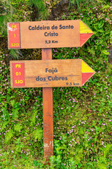 PR1 direction indicator sign for Caldera Fajã de Santo Cristo 5.2km, and Fajã dos Cubres 9.5km at the beginning of the trail. São Jorge Island-Azores-Portugal