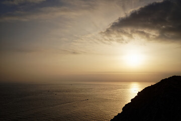 Scenic golden sunset over ocean by mountains