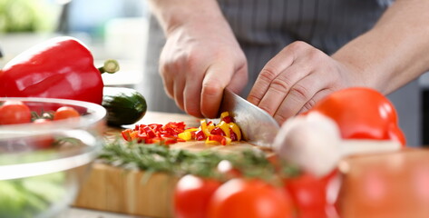 Culinary Chef Chopped Chili Pepper Small Slices. Man Cutting Ingredients by Sharp Knife on Wooden Board. Fresh and Healthy Food. Colorful and Delicious Dieting Salad Recipe Horizontal Photography
