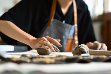 Young Artist Potter's hands molding clay on the table, Tactile process of pottery-making, Close-up image