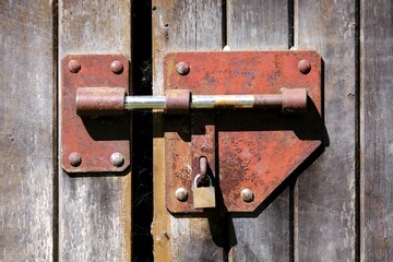 Lock with metal latch and padlock on wooden door