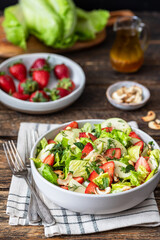 Fresh salad with lettuce leaves, apples, strawberries and cashew nuts	