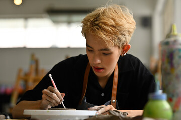 Young Asian Gay boy making DIY ceramic in the workshop, Art and craft with LGBT people