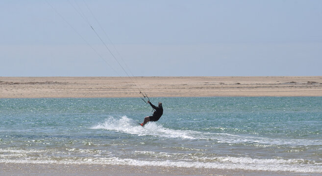 Male person kitesurfing at sea, vacation with fun and extreme sport