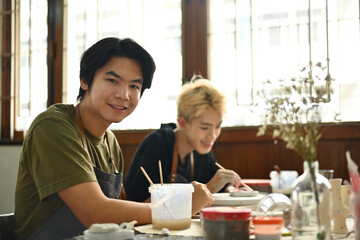 Portrait of Students enjoy their art class while painting ceramic pieces in Art class hours