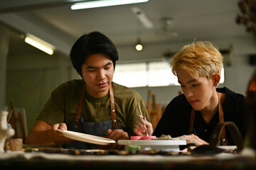 Students focused during art class hours, meticulously working on their ceramic projects. The image...