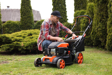 Fototapeta premium Man with modern lawn mower in garden