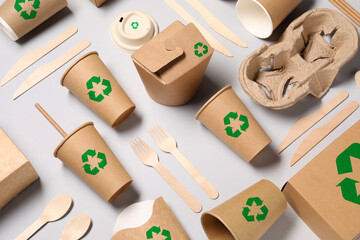 Set of eco friendly food packaging with recycling symbols on light background, flat lay