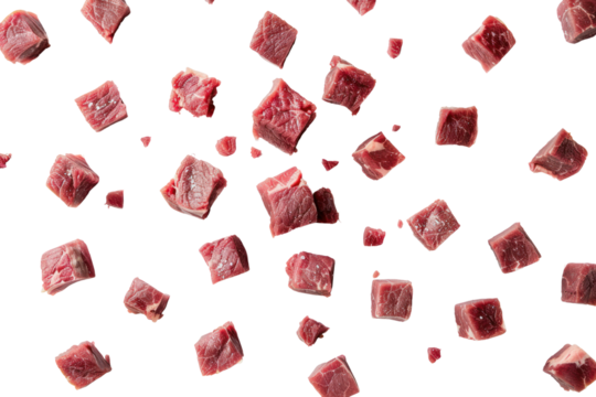 Raw beef meat cubes scattered across a white surface, like dice on a game board, isolated on white background