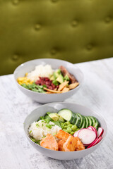 Bowls of fresh salads on a table by a green chair