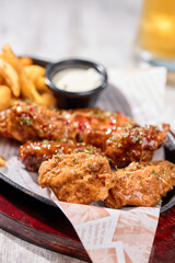 Chicken wings and fries on a tray, appetizing fast food