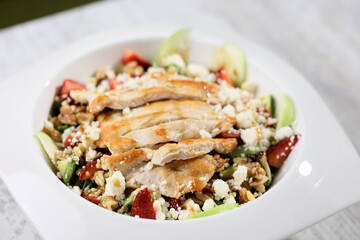 Salad with chicken and cheese on a white plate