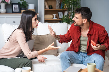 Young couple at home have a problem and argue due to jealousy caused by chatting and flirting via...