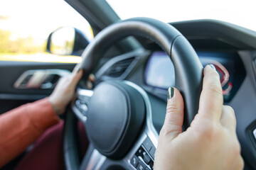 Driving a car. Woman hands holding steering wheel