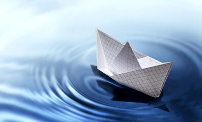 A paper boat drifts on calm water, symbolizing tranquility and creativity