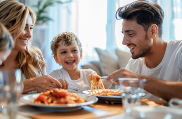 A happy family eating pasta together at the dining table, the dad is holding a fork with macaroni...