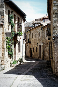 Narrow urban alley with old stone houses in the town of Pedraza, Spain