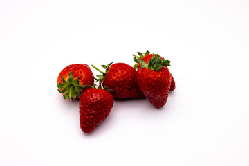 four strawberries sit side by side on the white surface
