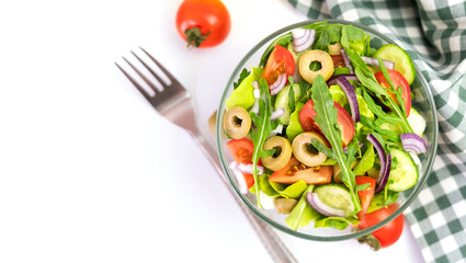 Healthy salad from fresh vegetables, green leaves, arugula and olives. Top view. Copy space. Selective focus.