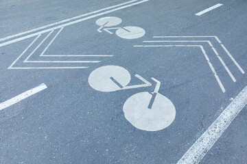 Bike lane with white bicycle sign on asphalt beside crosswalk on city street, road safety and...