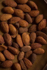 Nuts in a bowl and on a wooden table surface