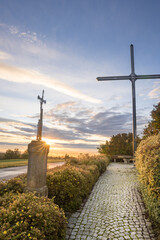 Vertical of a pathway lined with crosses at sunset
