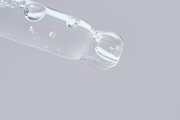 A glass pipette containing a cosmetic product.