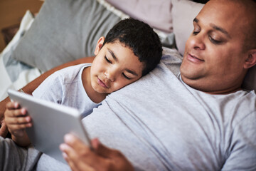 Father, son and tablet in bedroom for bonding with online streaming relaxing in home. Parent,...