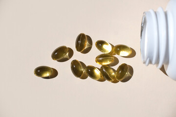 Cod liver oil omega 3 in a gel capsule on a pastel background.