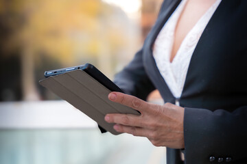 Portrait of a smiling middle-aged business woman with digital tablet in smiling hands looking at...