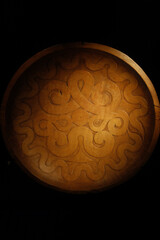 Decorative wooden tray with intricate carvings on a table