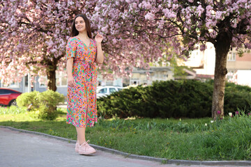 Beautiful woman and blossoming trees on spring day