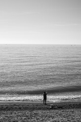 Lone fisherman on beach in Liguria, Itlay