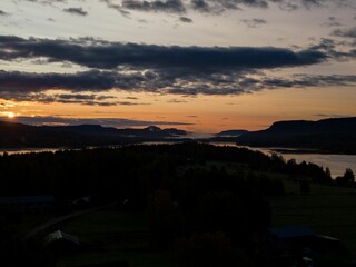 Vibrant sunset over a tranquil lake with mountains and trees