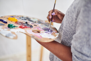 Hands, painting and palette with artistic person closeup in studio for creative expression or...