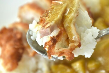 Tonkutsu crispy fried pork slice topping plain rice dressing potato and carrot in Japanese curry on plate 