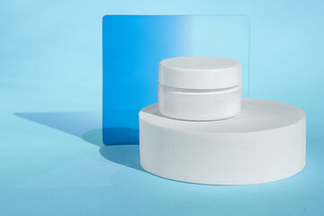 White cosmetic jar on blue background