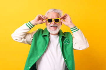 Portrait of grandpa with stylish sunglasses on yellow background