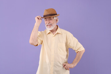 Portrait of stylish grandpa with hat on purple background