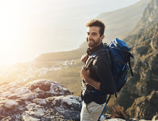 Portrait, mountains and hiking with man, smile and journey with nature, sunshine and getaway trip....