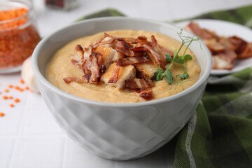 Delicious lentil soup with bacon and croutons on white table, closeup