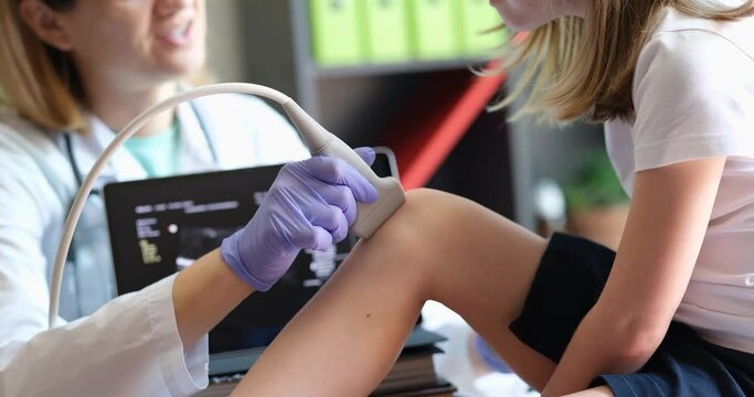 Child girl patient with orthopedic doctor in office and knee ultrasound. Ultrasound and medical examination of knee joints in children concept