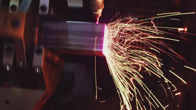 Working production equipment. A metalworking machine cuts a metal part with a laser beam. Close-up.