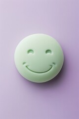 Fototapeta premium relieved emoji on a lavender background with space for copy The emoji is light green with a calm smile