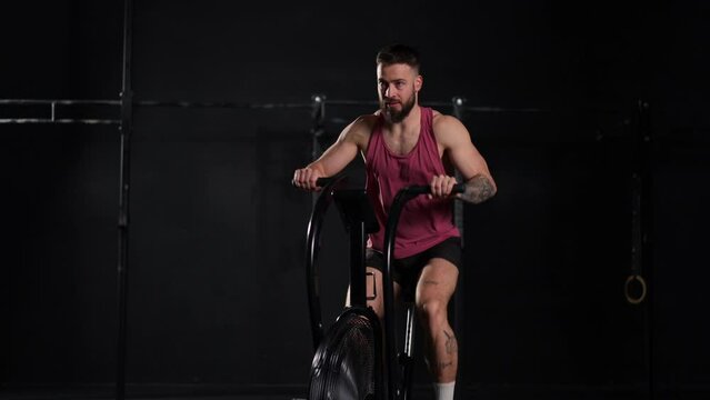 Man exercising on elliptical cross-trainer machine, wearing activewear. Routine workout for physical and mental health.