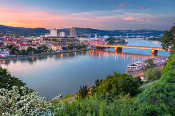 Linz, Austria. Aerial cityscape image of riverside Linz, Austria during spring sunset with reflection of the city lights in Danube river.