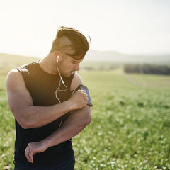 Runner, exercise and man in nature with armband for strong body, streaming music playlist and...