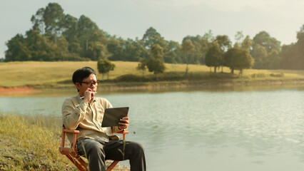 Content creator using tablet to writing script or production design for create new movie in beautiful location.